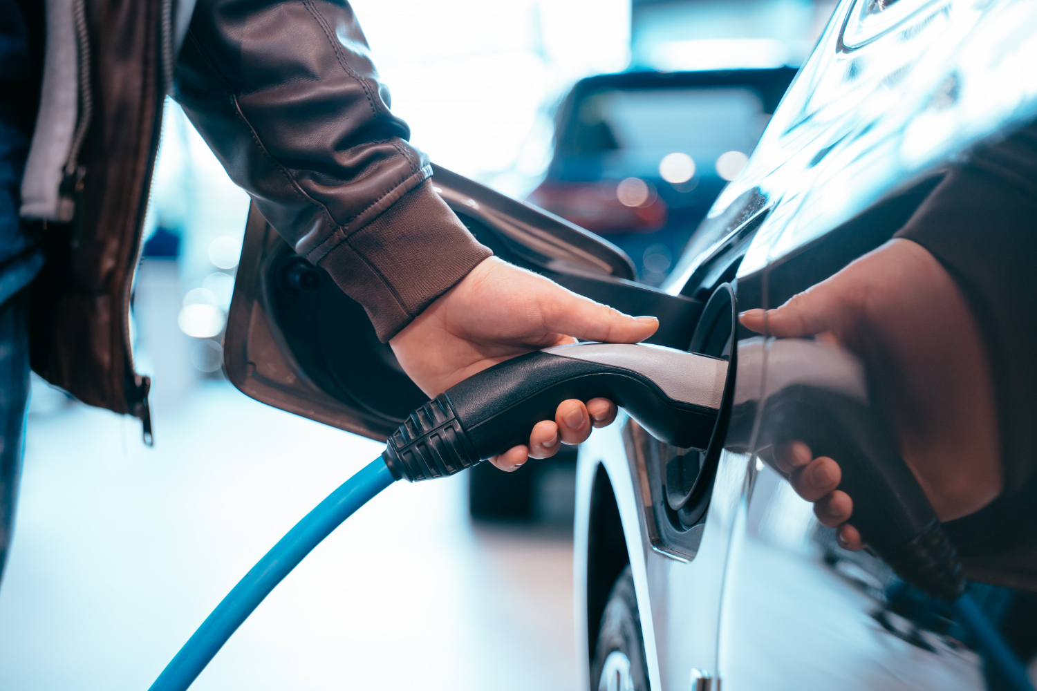 human-hand-is-holding-electric-car-charging-connect-electric-car